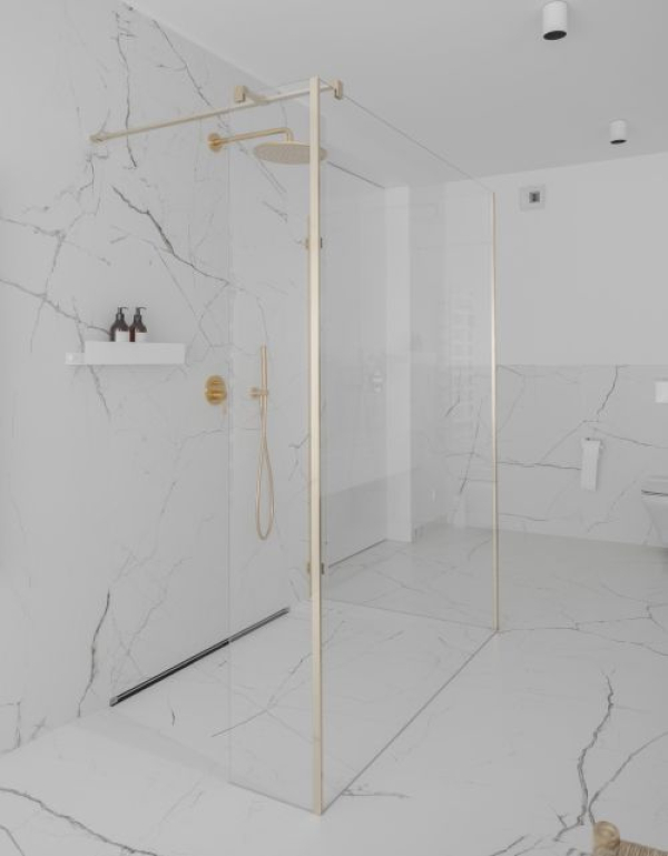 Minimalistyczna łazienka w bieli i złocie – zobacz inspirujące wnętrze, w którym króluje kabina Radaway
